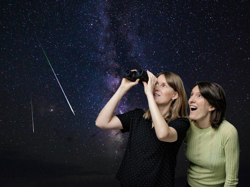 To personer står og kigger i stjernekikkert